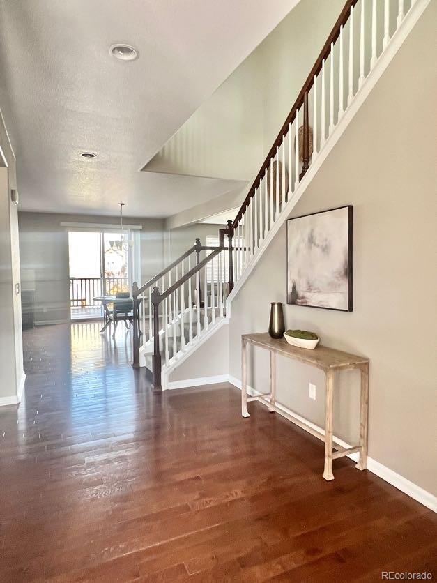 interior space featuring a notable chandelier, wood finished floors, and baseboards