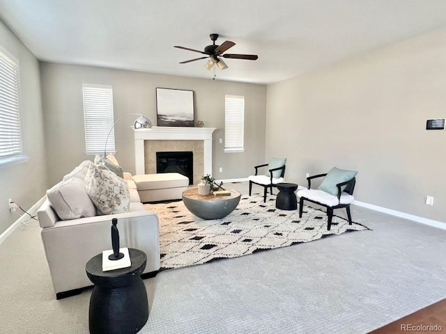 carpeted living room featuring a fireplace, baseboards, and ceiling fan