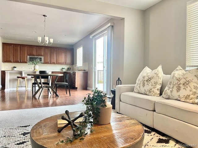 living area with light wood-style floors and an inviting chandelier