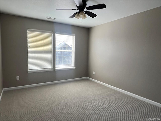 carpeted empty room featuring visible vents, baseboards, and a ceiling fan