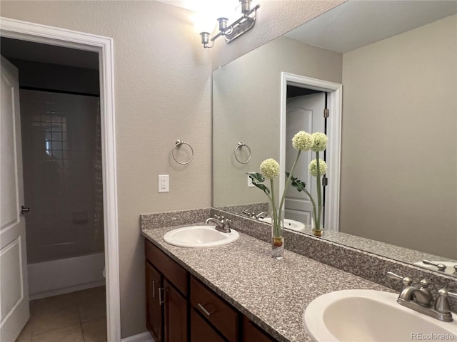 bathroom featuring tile patterned flooring, double vanity, washtub / shower combination, and a sink