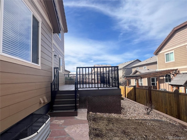 exterior space featuring fence, a residential view, and a wooden deck