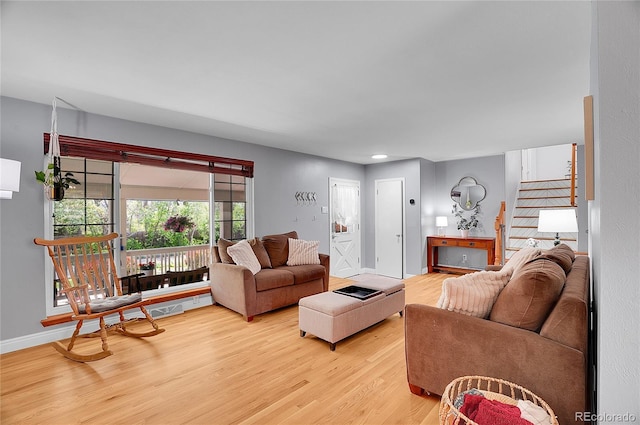 living area with recessed lighting, baseboards, stairs, and light wood-style flooring