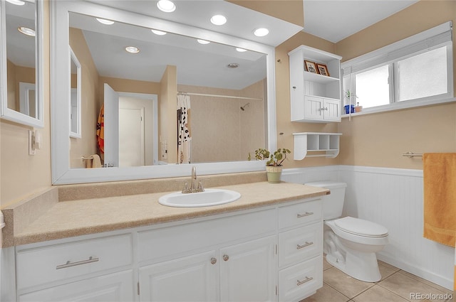bathroom featuring a shower with curtain, wainscoting, vanity, tile patterned floors, and toilet
