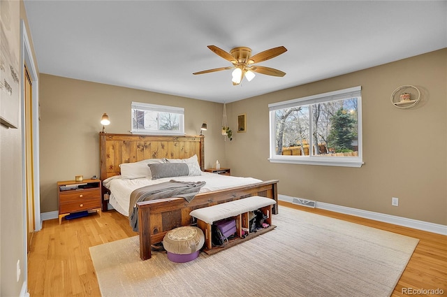 bedroom featuring light wood-style floors, multiple windows, and visible vents