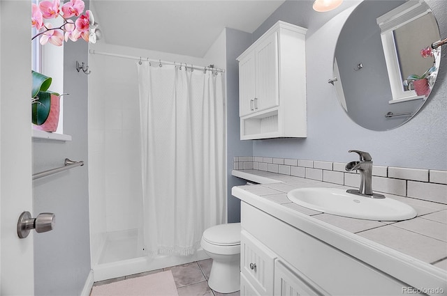 bathroom with a shower with curtain, decorative backsplash, vanity, tile patterned floors, and toilet
