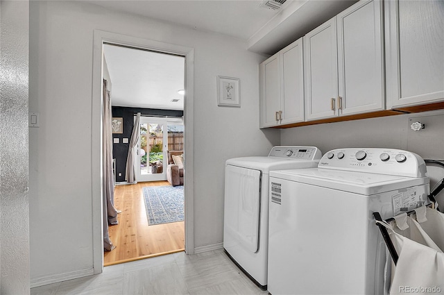 laundry area with cabinet space, baseboards, visible vents, and washing machine and dryer