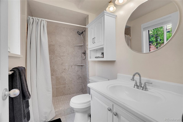 bathroom with vanity, tile patterned floors, toilet, and tiled shower