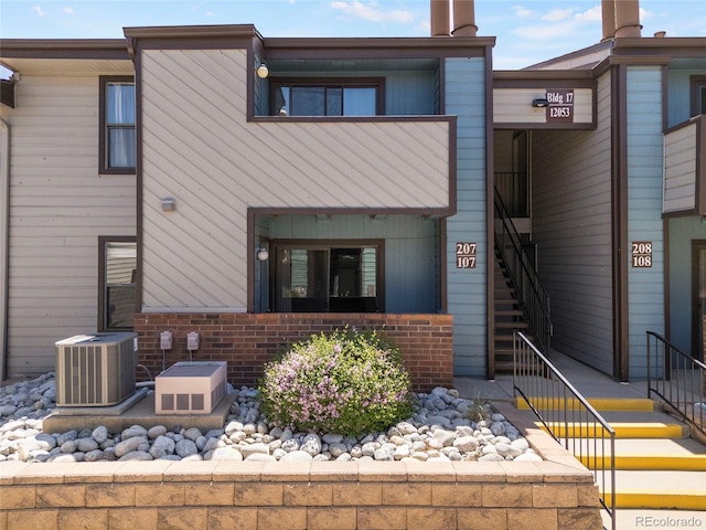 12053 E Harvard Ave Unit 107, Aurora, CO 80014 - view of front facade featuring stairway, central AC, and brick siding