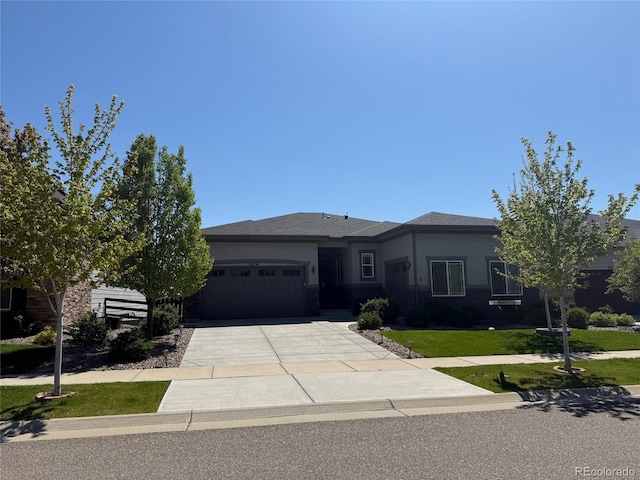 view of front facade with a garage, driveway, a front lawn, and stucco siding