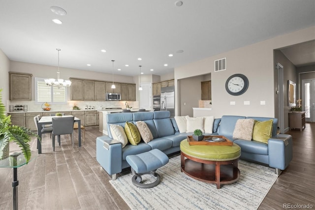 living area with a chandelier, light wood finished floors, and recessed lighting