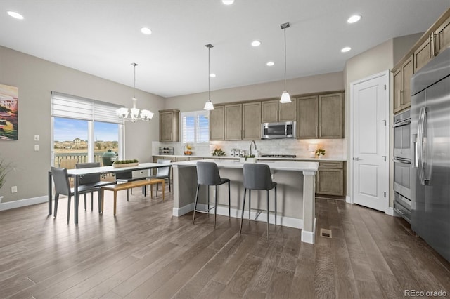 kitchen featuring stainless steel appliances, backsplash, dark wood-type flooring, a center island with sink, and recessed lighting