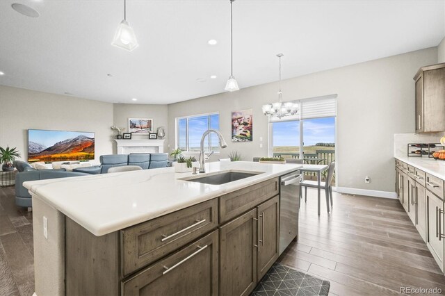 kitchen with a sink, wood finished floors, recessed lighting, dishwasher, and light countertops