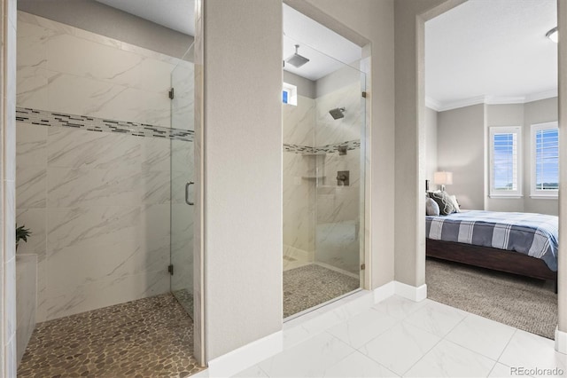 ensuite bathroom featuring marble finish flooring, crown molding, a shower stall, healthy amount of natural light, and baseboards