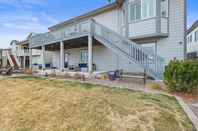 back of property with stairs, a wooden deck, a lawn, outdoor lounge area, and a patio area