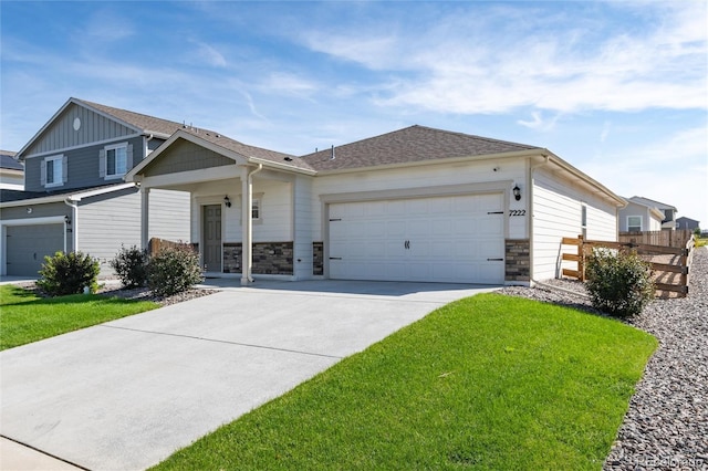 view of front facade with stone siding, a front lawn, an attached garage, and driveway