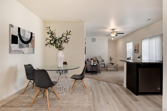 dining area featuring visible vents, ceiling fan, light wood-style flooring, and baseboards