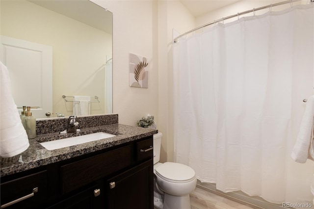 bathroom featuring toilet, a shower with curtain, wood finished floors, and vanity