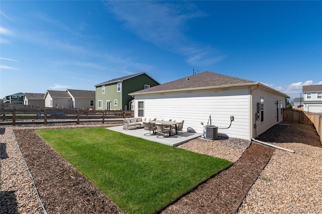 back of property featuring central AC unit, a fenced backyard, an outdoor living space, a yard, and a patio area