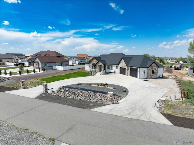 french country style house with stone siding, a residential view, and an attached garage
