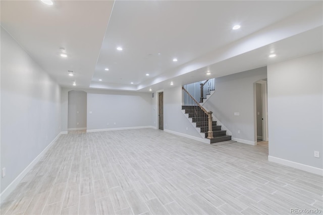 finished basement with stairs, recessed lighting, baseboards, and light wood finished floors
