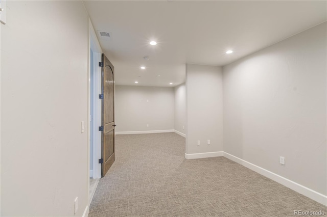 basement featuring recessed lighting, baseboards, and light carpet