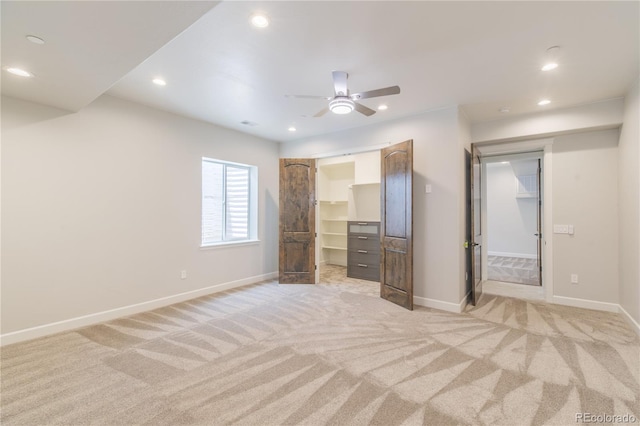 unfurnished bedroom with baseboards, light carpet, recessed lighting, a spacious closet, and a ceiling fan
