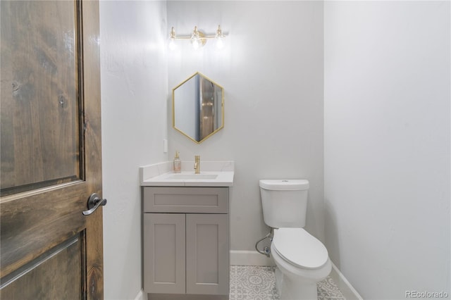 bathroom with baseboards, toilet, vanity, and tile patterned floors
