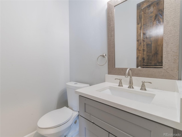 half bathroom with toilet and vanity