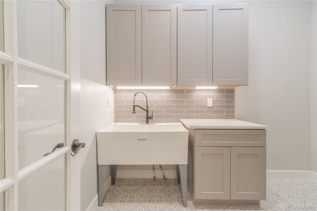 laundry area with a sink and baseboards