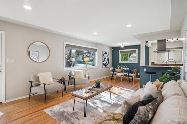 living area featuring recessed lighting, light wood finished floors, and baseboards