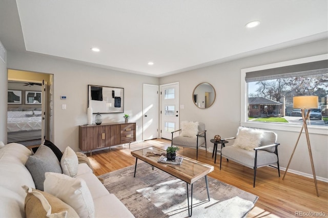 living room with baseboards, light wood-type flooring, and recessed lighting