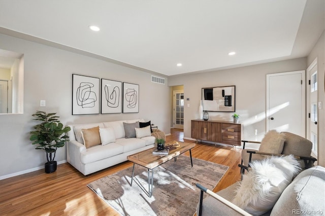 living area featuring visible vents, baseboards, recessed lighting, and light wood-style floors