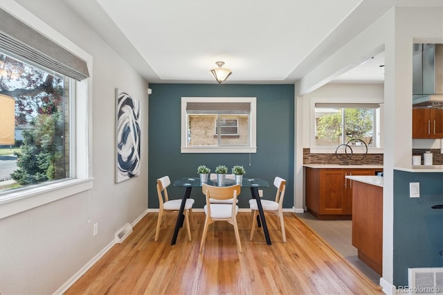 dining room featuring visible vents, baseboards, and light wood-type flooring