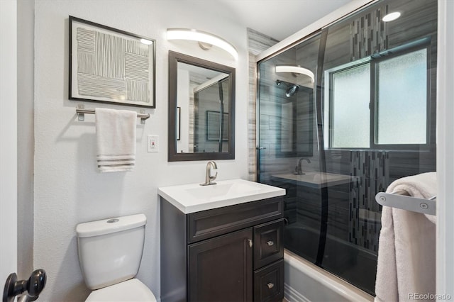 bathroom featuring bath / shower combo with glass door, vanity, and toilet