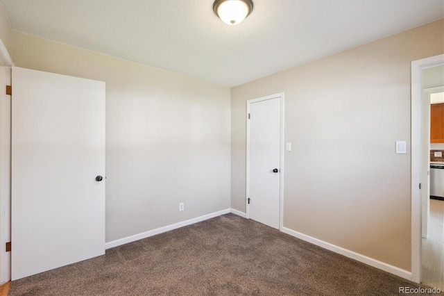 carpeted spare room featuring baseboards