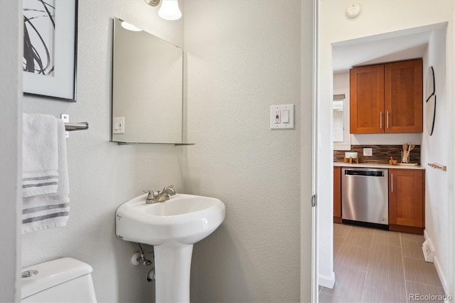 bathroom with a sink, toilet, and baseboards