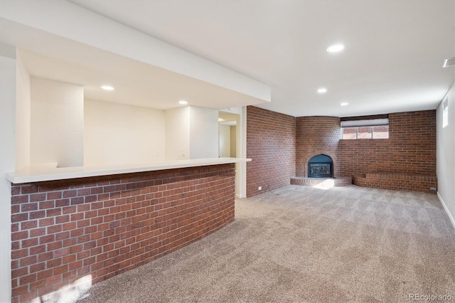 interior space with visible vents, brick wall, a wood stove, recessed lighting, and light carpet