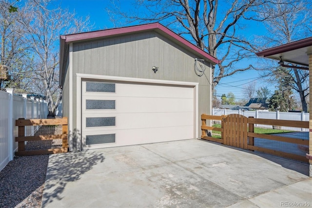 detached garage featuring fence and a gate
