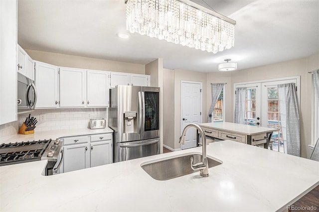 kitchen featuring stainless steel appliances, white cabinetry, sink, and french doors