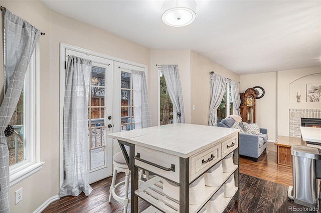 kitchen featuring a brick fireplace, dark hardwood / wood-style floors, and french doors