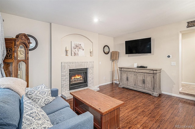 living room with dark wood-type flooring and a fireplace