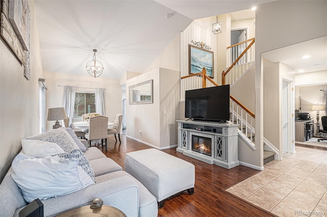 living room featuring an inviting chandelier, high vaulted ceiling, and hardwood / wood-style floors