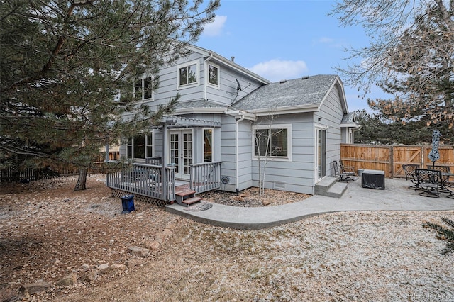 rear view of property featuring a patio, a wooden deck, and french doors