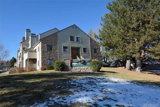 snow covered property featuring a lawn