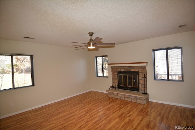 unfurnished living room with ceiling fan, wood-type flooring, and a textured ceiling