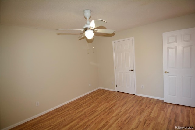 unfurnished room featuring a textured ceiling, light hardwood / wood-style flooring, and ceiling fan