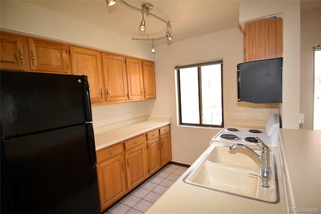 kitchen featuring black refrigerator, light tile patterned floors, white electric stove, and sink