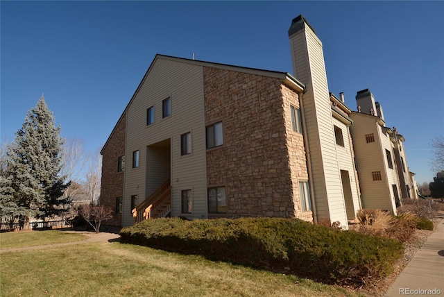 view of side of property featuring a yard and a chimney