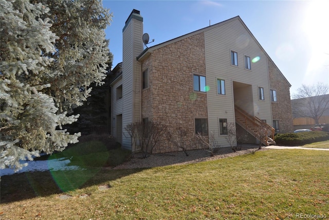 view of property exterior featuring a yard, stairway, and a chimney